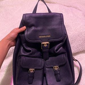 Black pebble leather Michael Kors Susie flap backpack.